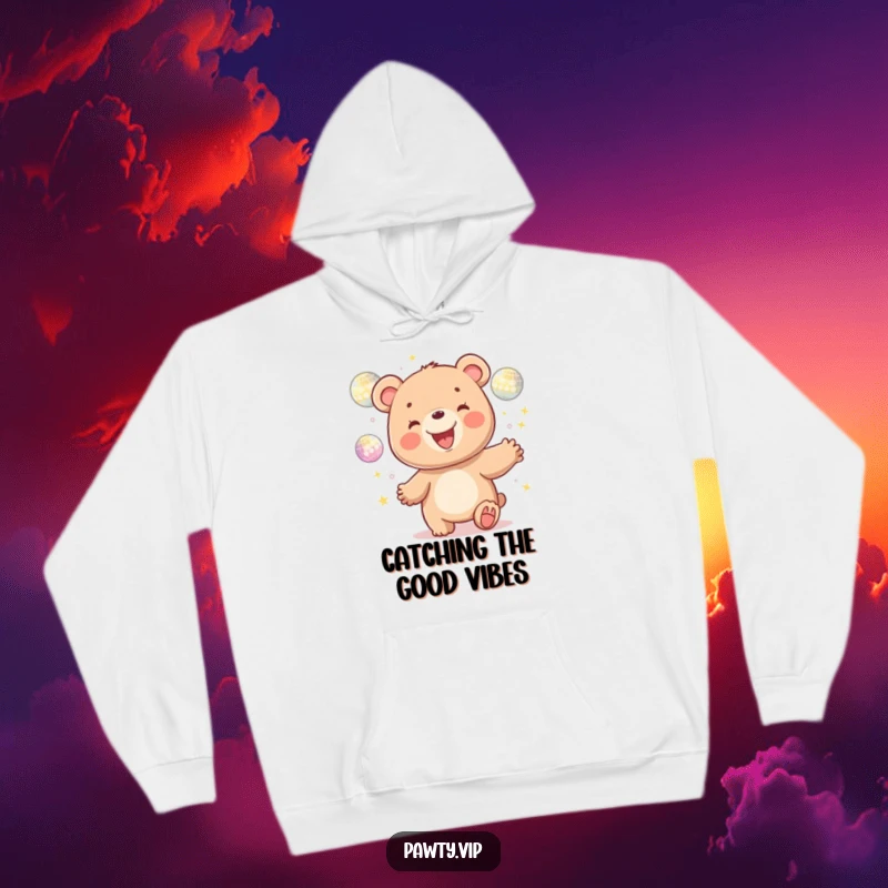 Funny kawaii bear character gleefully juggling shiny disco balls, featured on a comfortable hoodie for maximum humorous appeal.